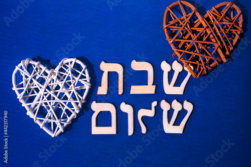 Hebrew letters meaning Shabbat Shalom, in English - Peaceful Saturday. on blue background