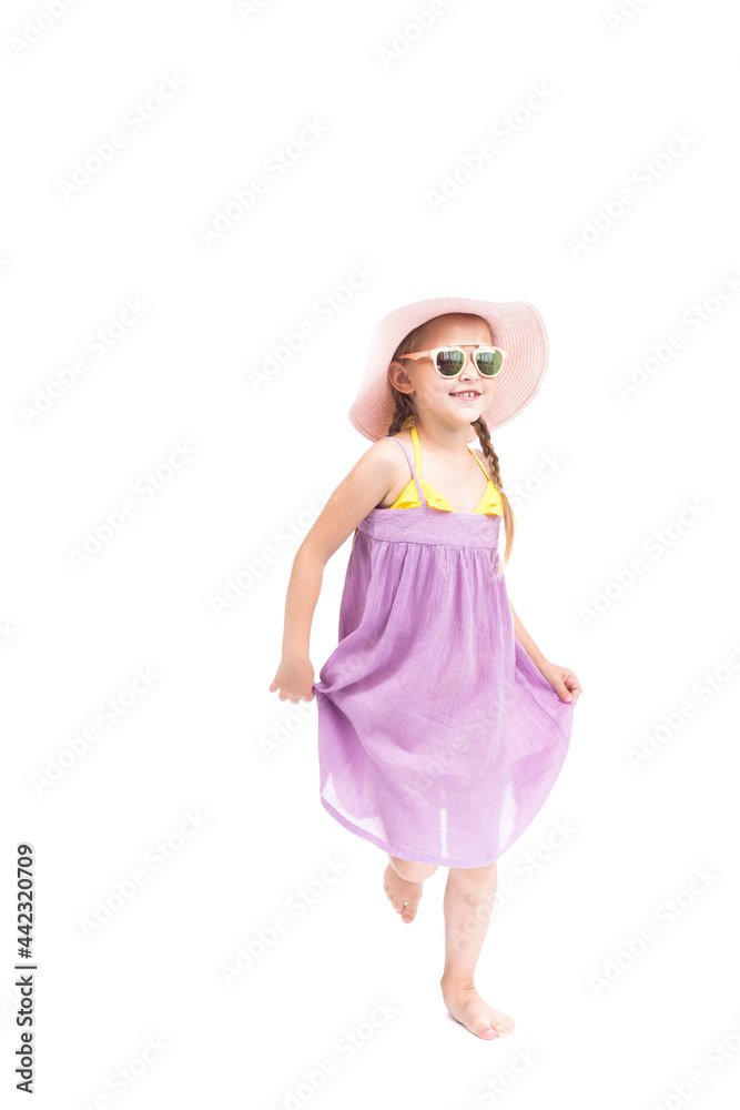 Vertical full length studio portrait of cute Caucasian girl wearing summer dress, sunglasses and hat posing on camera, white background Vertical full length studio portrait of cute Caucasian girl wearing summer dress, sunglasses and hat posing on camera, white background