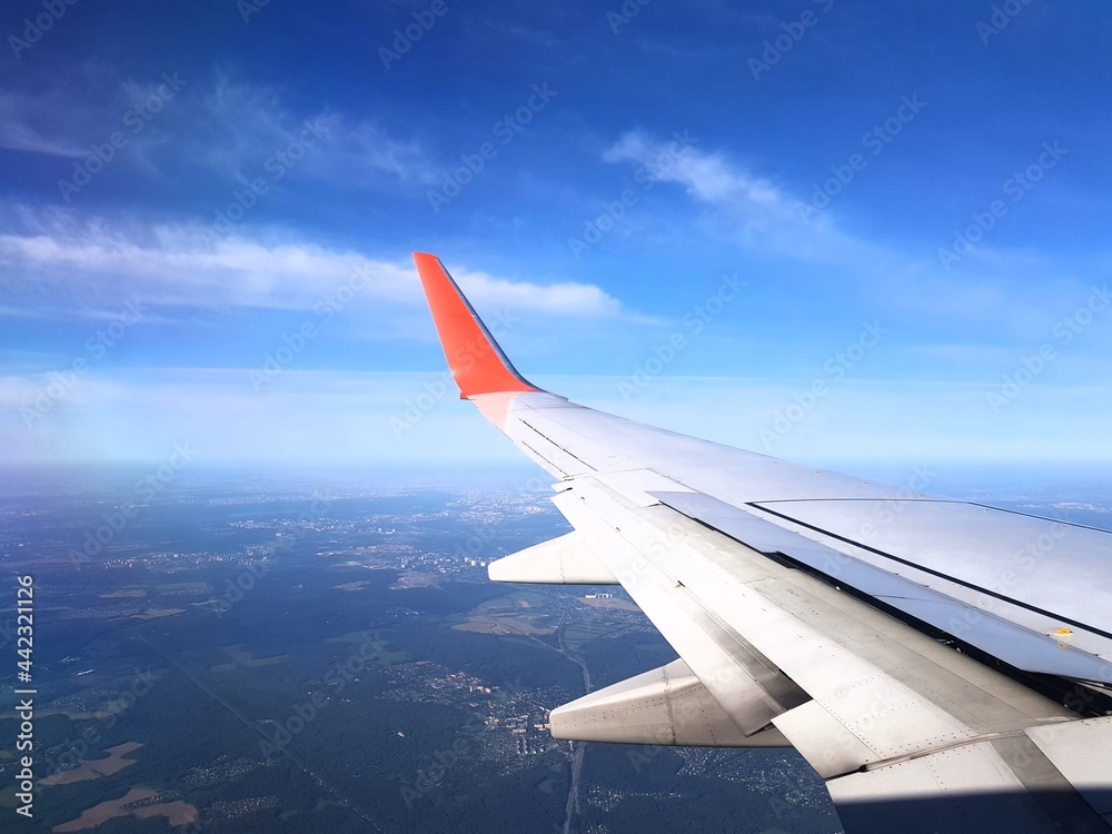 Airplane wing in the blue sky