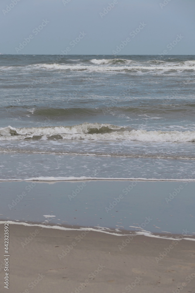 Portrait of waves breaking onto a sandy beach Portrait of waves breaking onto a sandy beach
