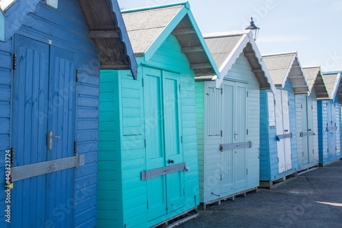 Line of blue and green painted wooden beach huts © Ian Dyball