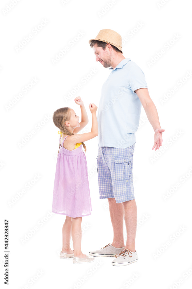 Vertical full length side view portrait of modern handsome Caucasian father spending time with his cute little daughter having fun together Vertical full length side view portrait of modern handsome Caucasian father spending time with his cute little daughter having fun together