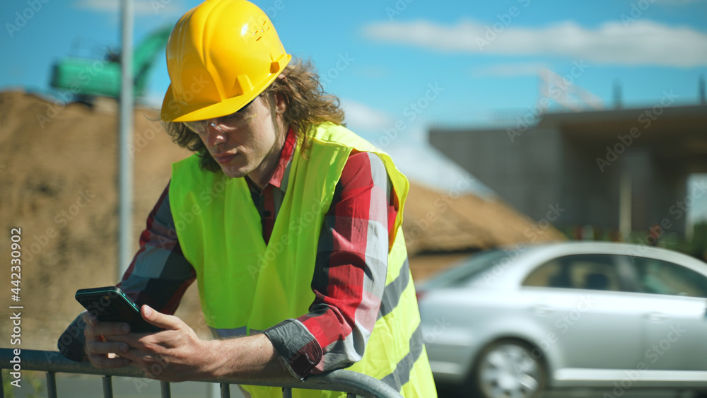 Obraz premium Builder talking by smartphone at construction site.