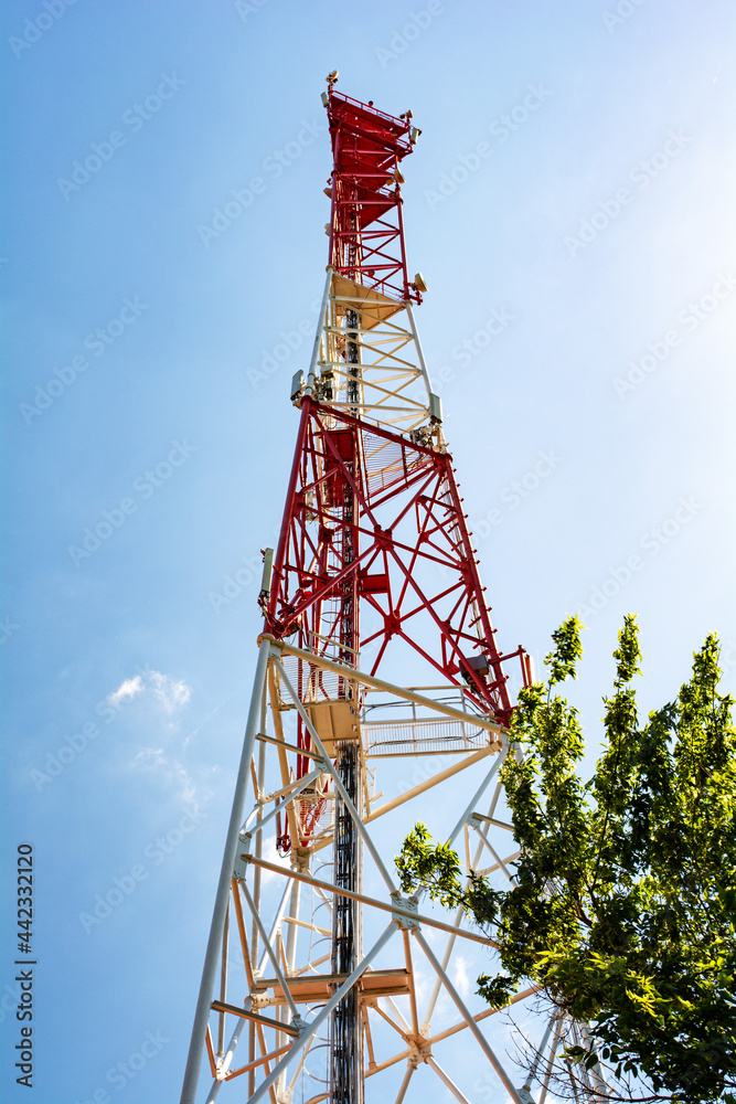 Cellular telecommunication tower on blue sky with bright sunlight Cellular telecommunication tower on blue sky with bright sunlight