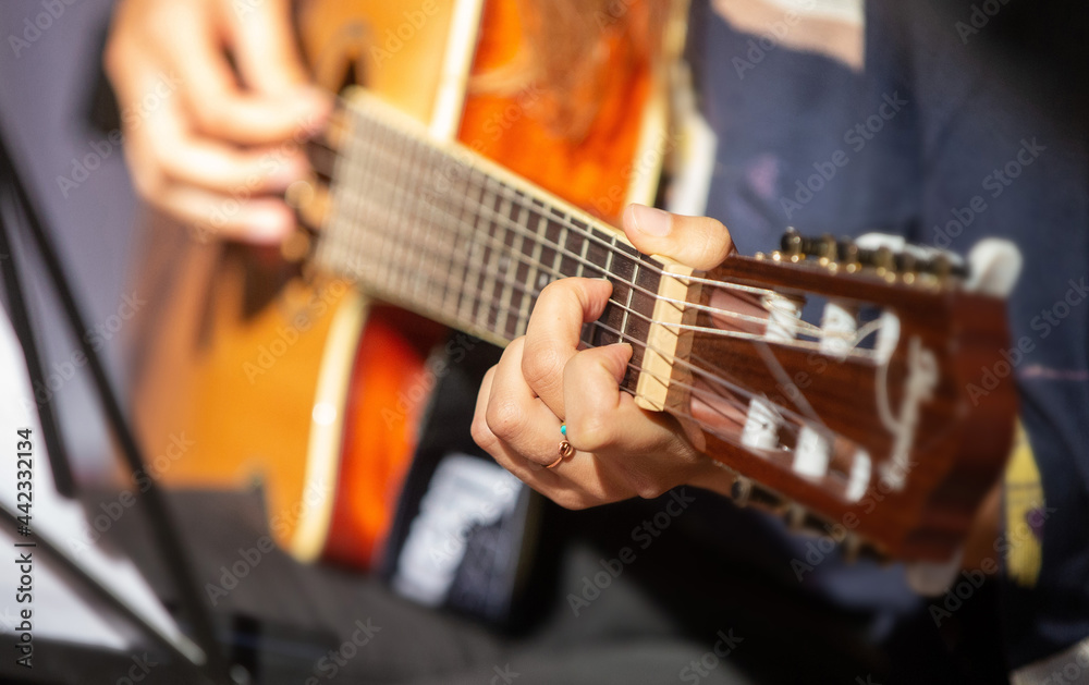 musician playing the guitar fingers on strings close up