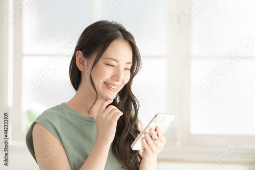 Fotografie, Obraz スマホでアプリを見る美しい日本人女性1　右にコピースペースあり