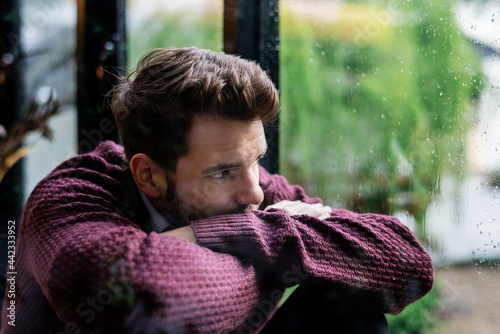 Foto Thoughtful man looking out the window