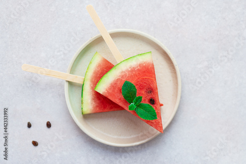 Watermelon slices with mint leaves in a plate. Horizontal orientation, top view, flat lay.