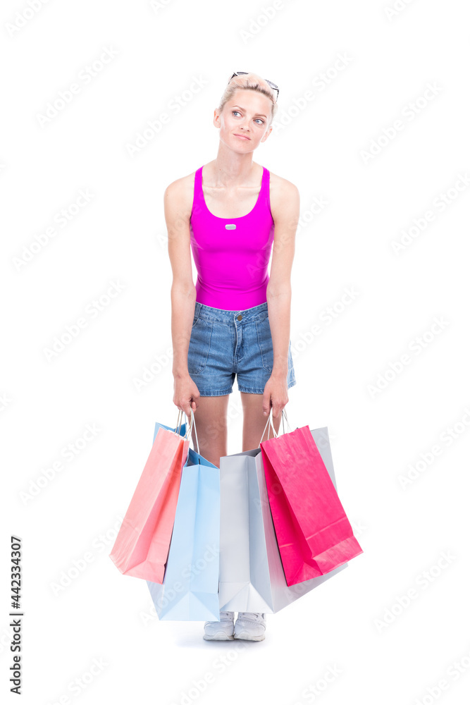 Vertical full length studio portrait of stylish young woman wearing summer outfit carrying shopping bags, white background Vertical full length studio portrait of stylish young woman wearing summer outfit carrying shopping bags, white background