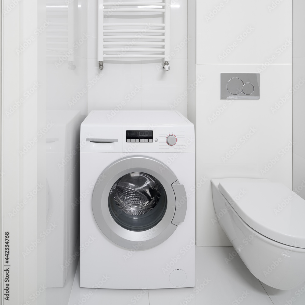 Close-up on washing machine in white bathroom Close-up on washing machine in white bathroom