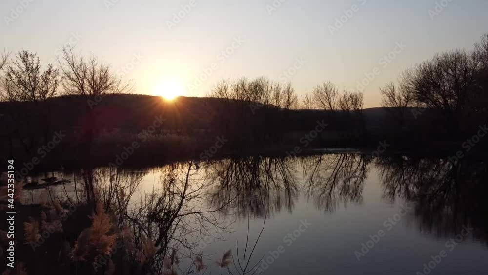Aerial cinema: drone flying over the river at sunset. Sunset over the river. Evening sunset. Top view of a beautiful landscape. Aerial cinema: drone flying over the river at sunset. Sunset over the river. Evening sunset. Top view of a beautiful landscape.