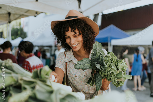 Beautiful woman buying kale at a farmers market