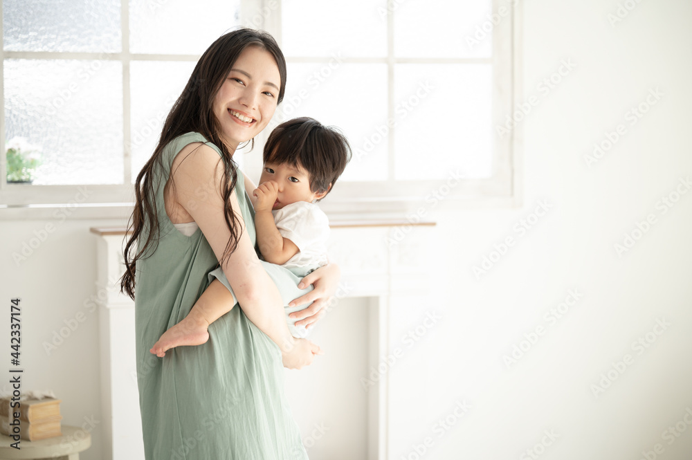 赤ちゃんを白い綺麗な部屋で抱っこする笑顔の美人ママ3 カメラ目線コピースペースあり Stock Photo Adobe Stock