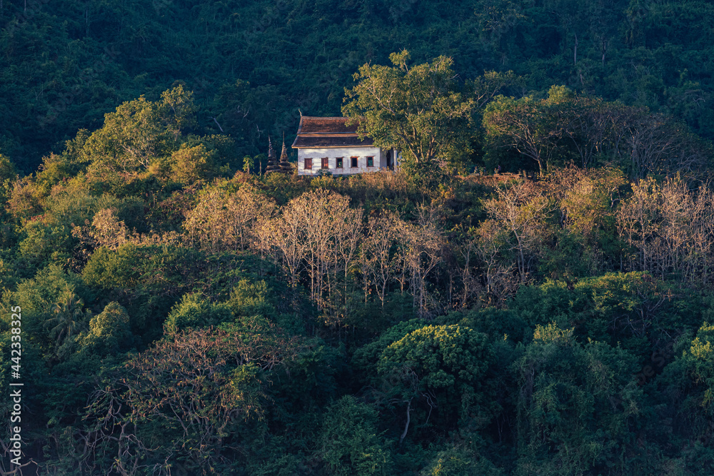 Beautiful Buddhist temple on the hill around with forest and soft sunlight in the afternoon, Wat Chomphet with big mountain background at Luang Prabang, Laos. Beautiful Buddhist temple on the hill around with forest and soft sunlight in the afternoon, Wat Chomphet with big mountain background at Luang Prabang, Laos.