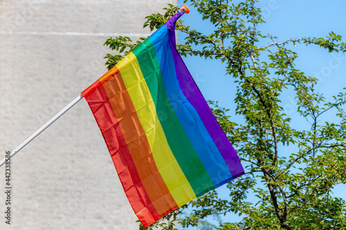Photography Celebration of Pride month in Amsterdam with rainbow flag hanging outside building along street, The symbol of gay, lesbian, bisexaul and trangender, LGBT social movments in Netherlands