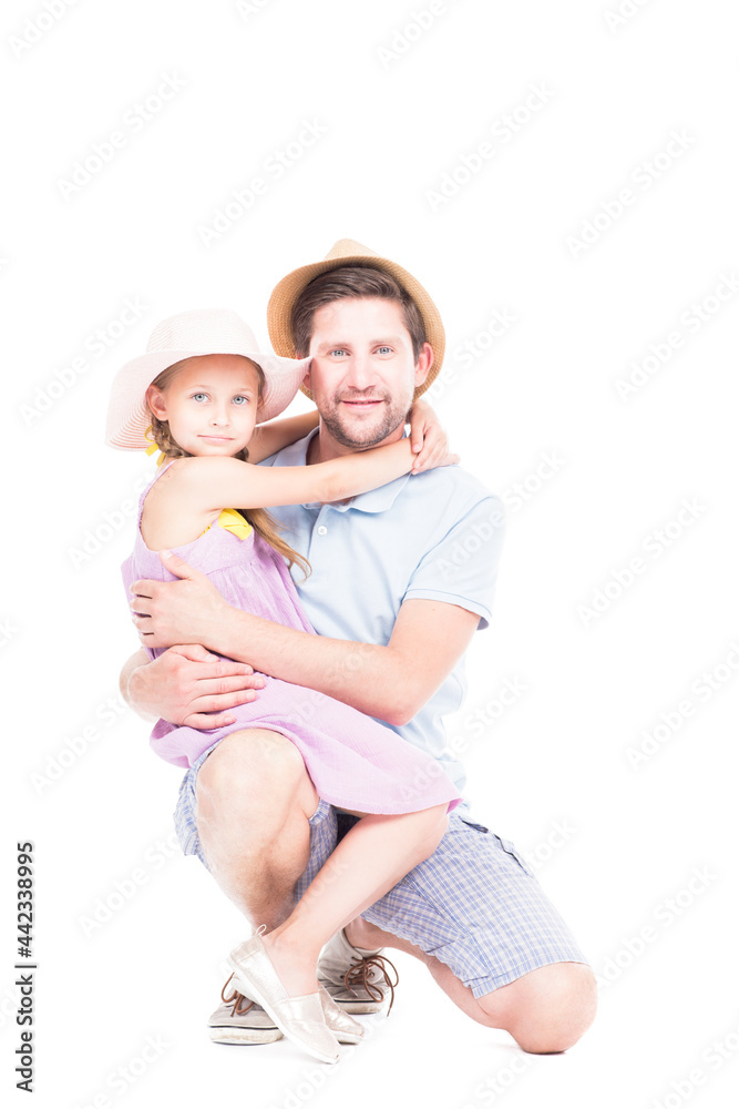 Vertical studio portrait of happy father and her cute daughter wearing summer outfits hugging each other looking at camera, white background Vertical studio portrait of happy father and her cute daughter wearing summer outfits hugging each other looking at camera, white background