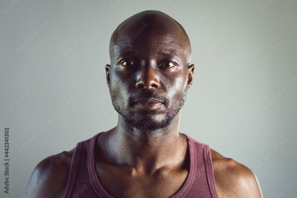 Portrait of fit african american man exercising at gym, looking straight to camera