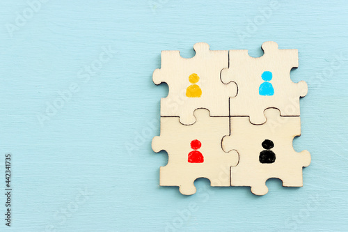 business concept image of puzzle blocks with people icons over wooden table ,human resources and management concept