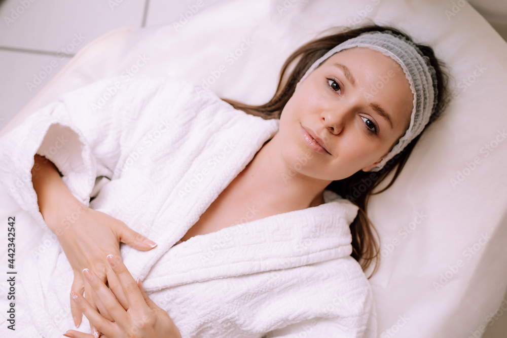 Close-up of young smiling young woman getting spa massage treatment at beauty spa salon. Spa skin and body care. Facial care. Cosmetology Close-up of young smiling young woman getting spa massage treatment at beauty spa salon. Spa skin and body care. Facial care. Cosmetology