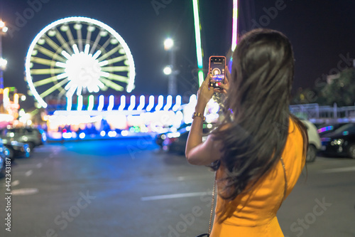 Beautiful brunette woman at amusement park in the night photo