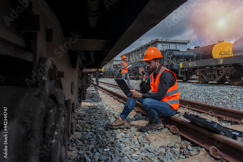 Foto worker sitting on rail with checking folder in hand  on worker  background