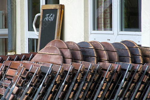 Fototapeta Naklejka Na Ścianę i Meble -  Geschlossenes Restaurant. Zusammengeklappte Stühle und eine leere Tafel als Speisekarte mit Aufschrifft: to go