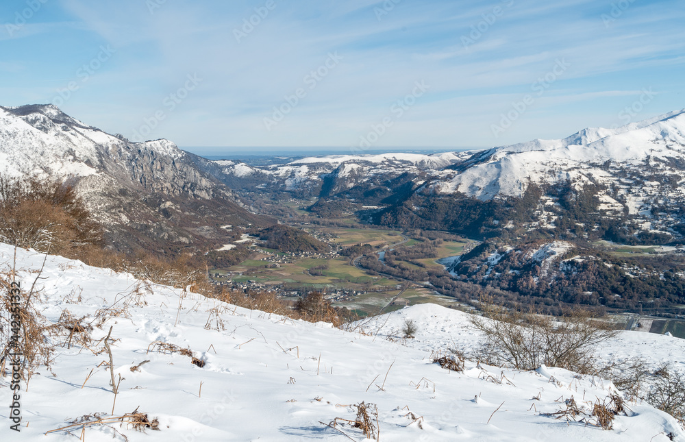 View of from Mont de Gez looking south down the valley of the Ousse river with snow-covered mountains in the French Pyrenees, Argelès-Gazost, Hautes-Pyrénées, Occitanie