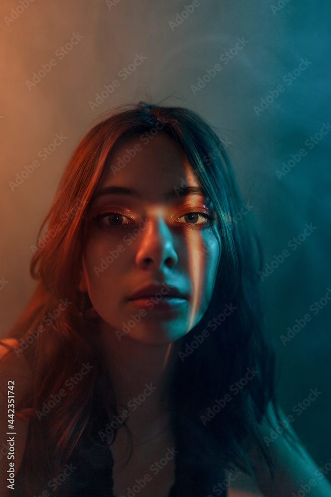 Sensual woman in dark room with light projection on face Sensual woman in dark room with light projection on face