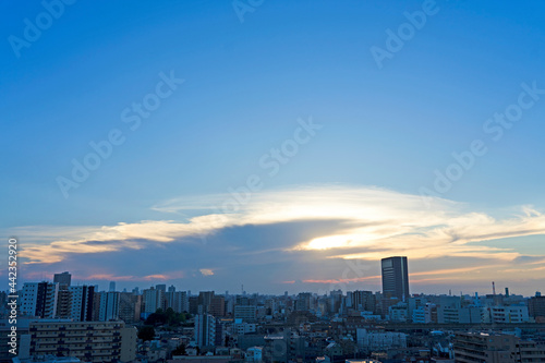 雲間から見える夕日と街 © Hisaya 