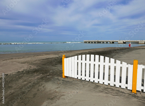 uno steccato bianco sulla solitaria spiaggia del mare in inverno