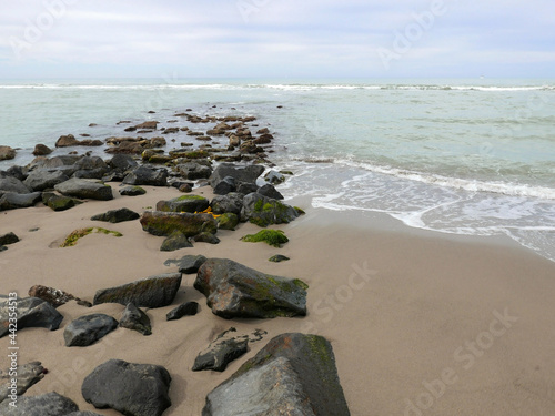 suggestiva vista di scogli lungo la riva della spiaggi ain inverno in un giorno plumbeo photo