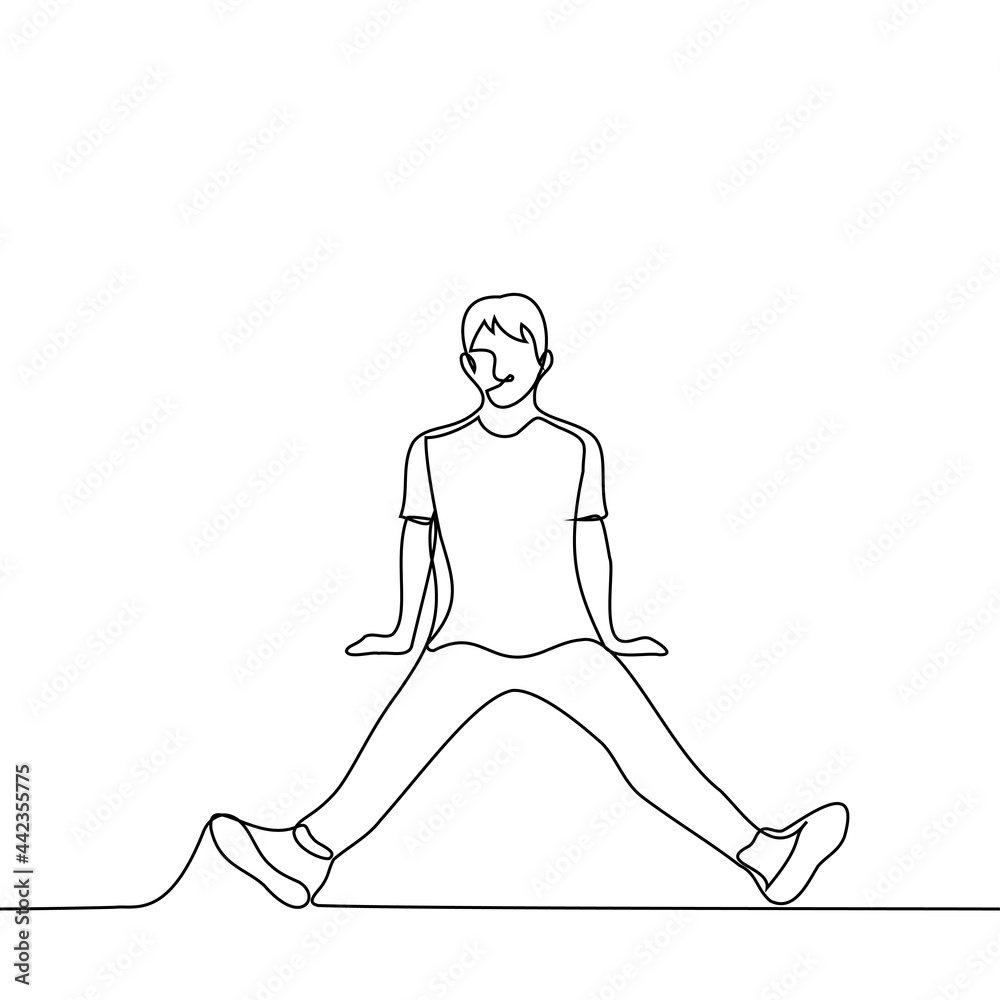 man sits on the floor with his legs wide apart to the sides of his arms ...