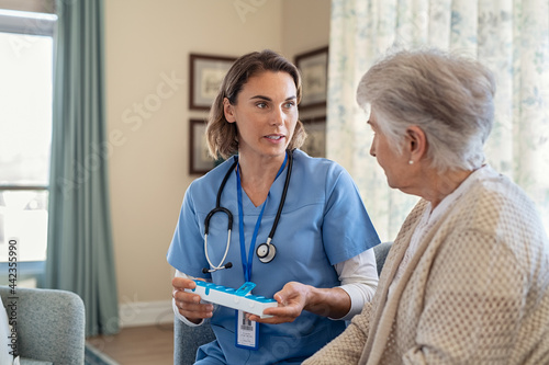 Nurse explaining medicine dosage to senior woman at nursing home