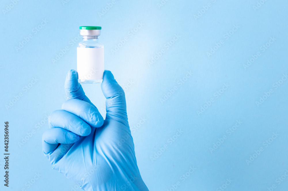 Medicine bottle for injection, Medical glass vial for vaccination. Science equipment, liquid drug or vaccine from treatment, flu in laboratory, hospital or pharmacy, copy space blue background. Medicine bottle for injection, Medical glass vial for vaccination. Science equipment, liquid drug or vaccine from treatment, flu in laboratory, hospital or pharmacy, copy space blue background.