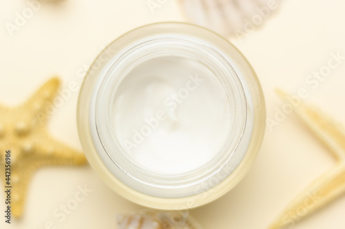 Skincare for summer – closeup of a moisturizer and shells.