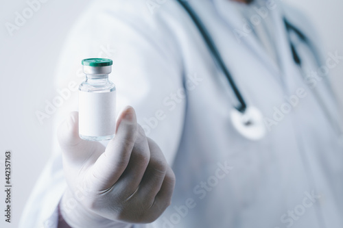 Doctor holding single bottle vial of vaccine for children or adults. Concept fight against virus. Medical health care concept vaccination hypodermic injection treatment vintage background.