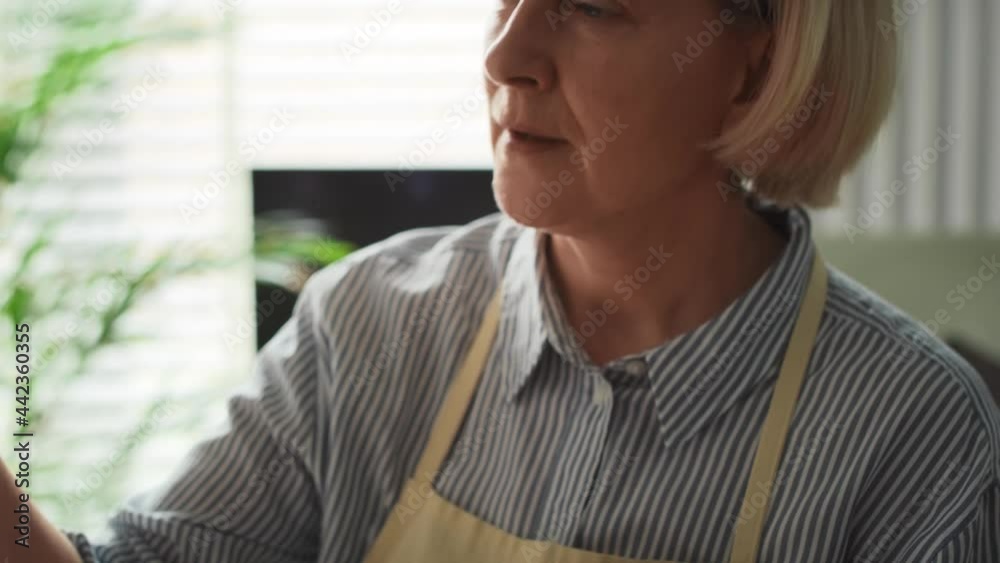 Tracking video of senior woman painting at easel. Shot with RED helium camera in 8K. Tracking video of senior woman painting at easel. Shot with RED helium camera in 8K.