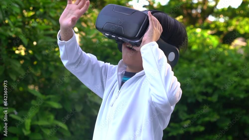 Asian Child With Virtual Reality Headset Touching Outdoors Asian Child With Virtual Reality Headset Touching Outdoors