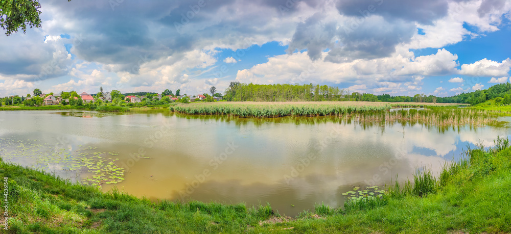 Fototapeta premium Landscape with a lake and clouds in the sky in the summer season