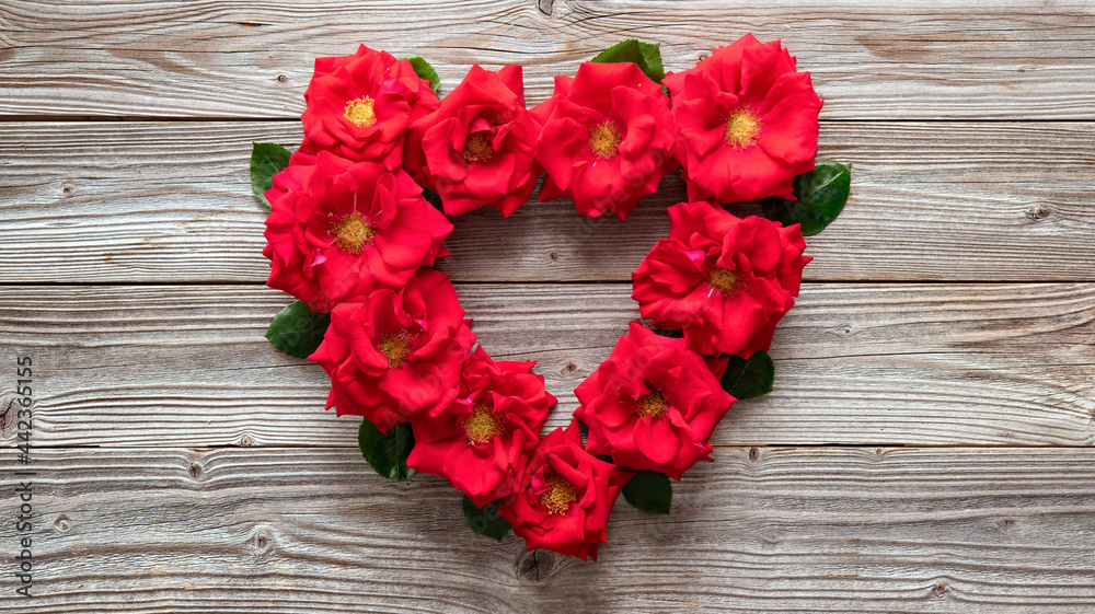 Heart shape of red roses on rustic wooden board Heart shape of red roses on rustic wooden board