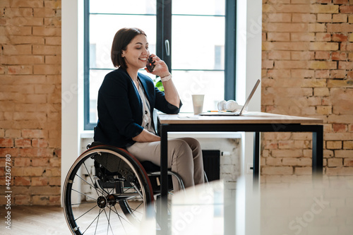 Print op canvas Young disabled business woman in wheelchair working