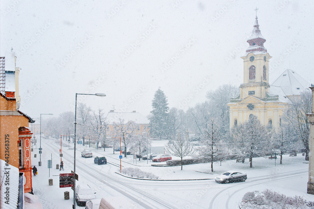 Square with baroque church in the winter. Postoloprty town. Czech Republic.