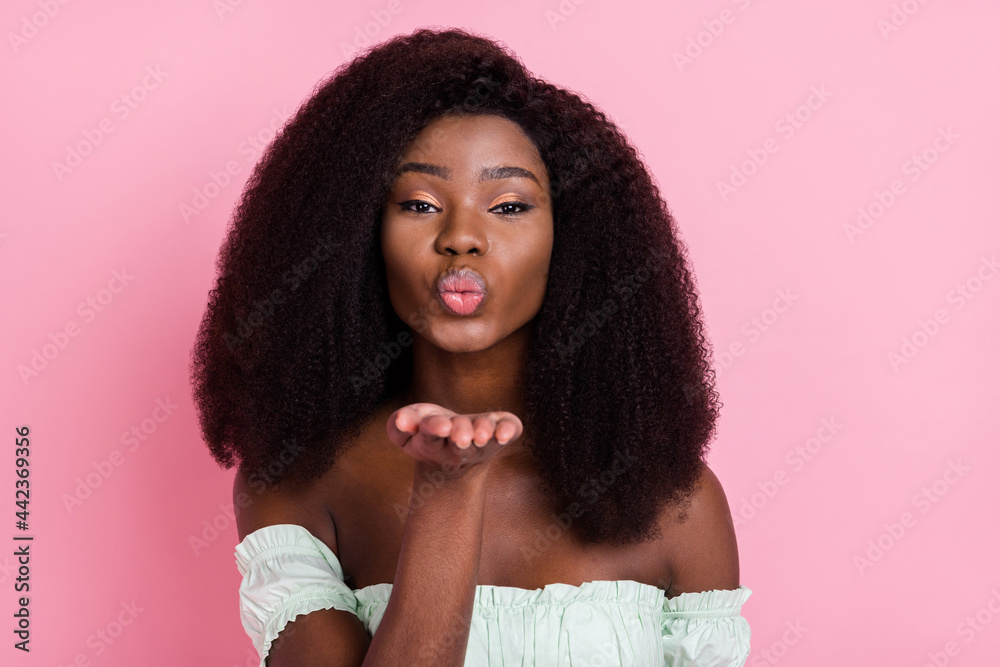Close-up portrait of attractive amorous wavy-haired girl sending air kiss isolated over pink pastel color background Close-up portrait of attractive amorous wavy-haired girl sending air kiss isolated over pink pastel color background