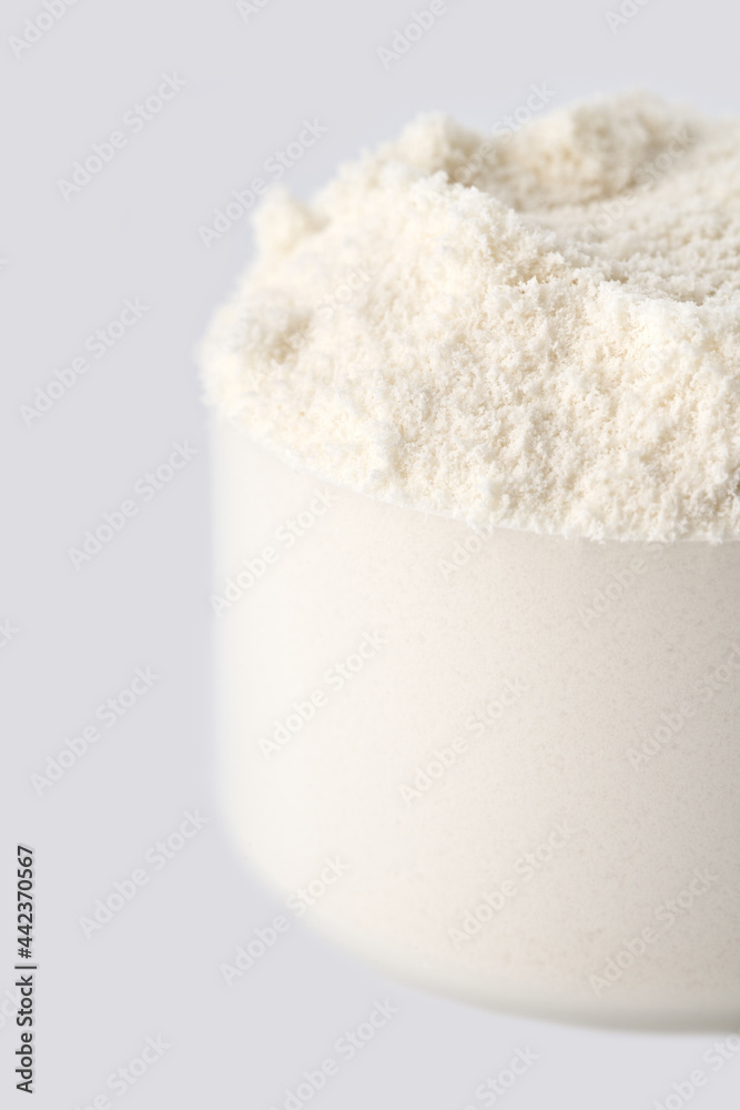 Heap of protein powder on white background. Scoops Of Protein Powder. Measuring spoon and heap of vanilla protein powder. Heap of protein powder on white background. Scoops Of Protein Powder. Measuring spoon and heap of vanilla protein powder.