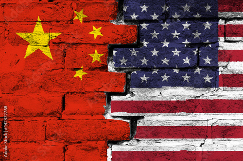 Concept of the relationship between China and the United States of America with two painted flags on a damaged brick wall