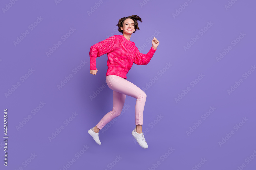 Full size profile side photo of young active girl happy positive smile jump run hurry sale isolated over purple color background Full size profile side photo of young active girl happy positive smile jump run hurry sale isolated over purple color background