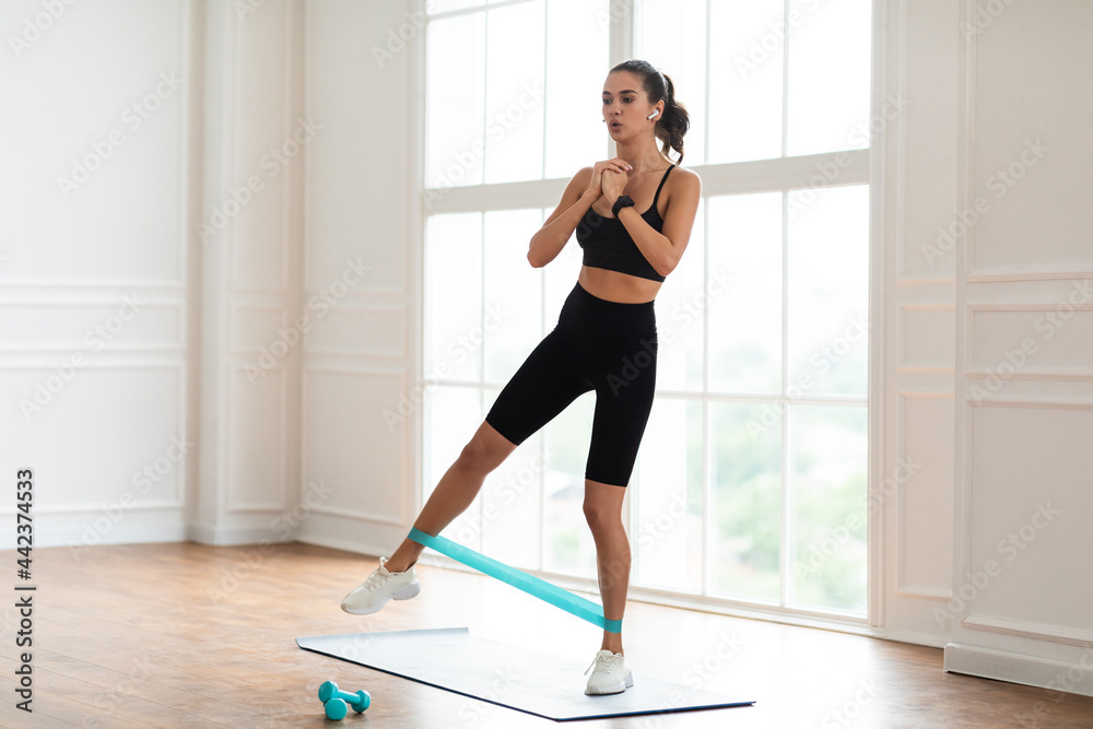 Fototapeta premium Focused Woman In Sportswear Exercising With Band