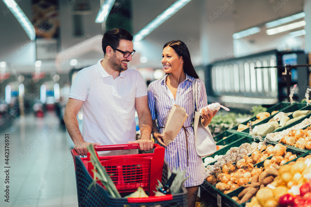 Happy couple buying fruit at grocery store or supermarket