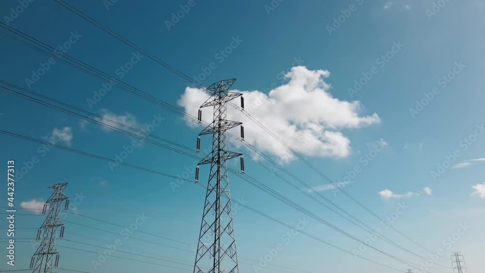 Aerial drone view of a newly constructed electric transmission tower on a green rice field Aerial drone view of a newly constructed electric transmission tower on a green rice field