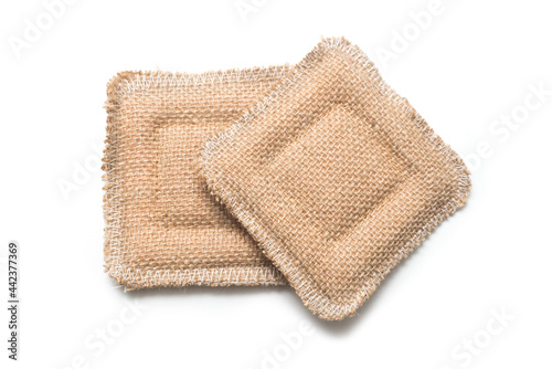 Closeup of two hessian sponges on white background